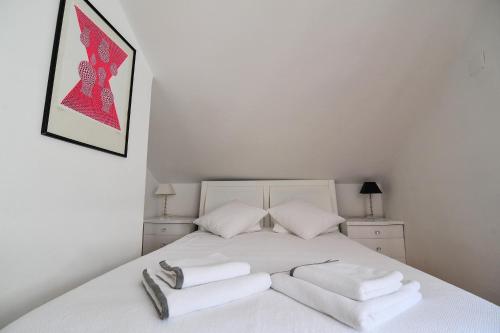 a bedroom with a white bed with towels on it at House Vilović Korčula in Korčula