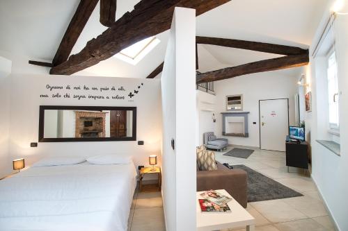 a bedroom with a white bed and a living room at ReArduinoIvrea in Ivrea