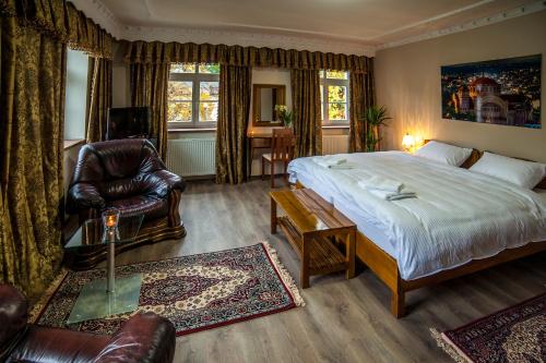 ein Schlafzimmer mit einem Bett, einem Stuhl und einem Tisch in der Unterkunft Pension Olympion in Jihlava