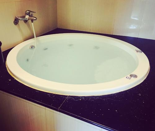 a white bath tub with a faucet in a bathroom at Songfeng Xiuxian Homestay in Puli