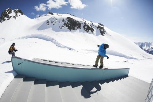 a man riding a snowboard on a ramp in the snow at Haus Rudigier by Châtel Reizen in Sankt Gallenkirch
