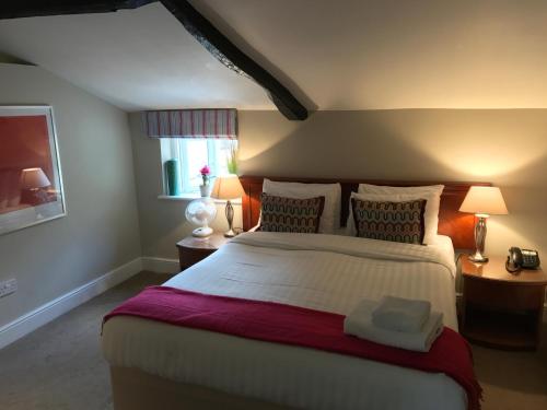 a bedroom with a large bed and two lamps at The Black Swan Inn in Norwich