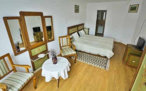 1 dormitorio con 1 cama, mesa y sillas en Casa Júlia, en Odorheiu Secuiesc