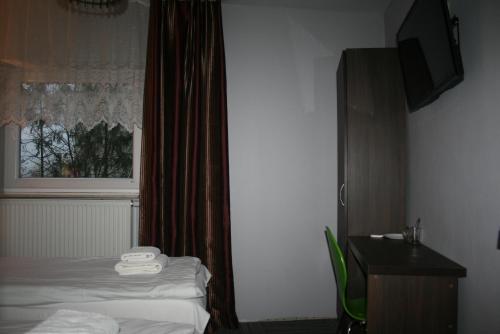 a hotel room with a bed and a window at Pokoje Gościnne Tessa in Chełm