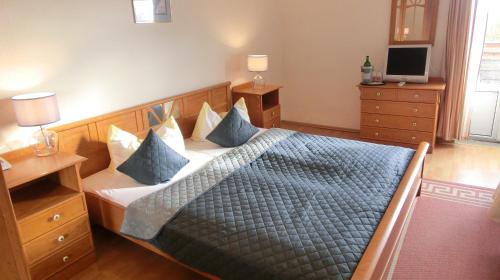 a bedroom with a bed with blue pillows at Hotel Seelust in Hohwacht