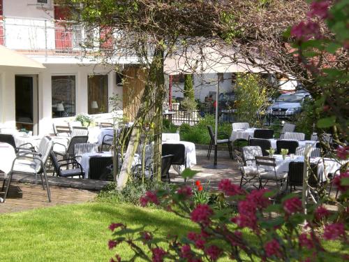 a group of tables and chairs in a garden at Hotel KAMPS in Sinsheim