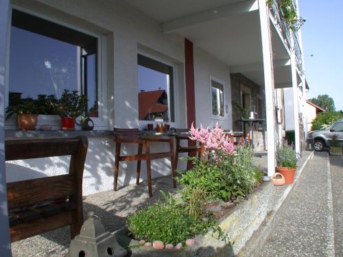 a porch of a house with benches and plants at Hotel KAMPS in Sinsheim