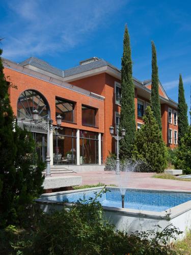 a brick building with a fountain in front of it at Apartamentos TH La Florida in Madrid