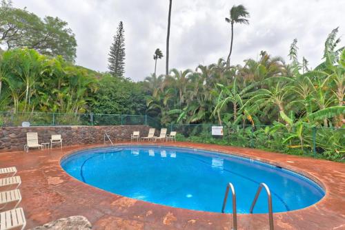 - une piscine dans un complexe avec des chaises et des arbres dans l'établissement Kaanapali Plantation Condominiums, à Kaanapali