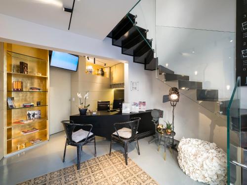 a room with a desk and chairs and a staircase at Duomo Suites & Spa in Catania