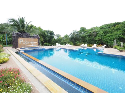 a pool at a resort with chairs and trees at Poonsap Resort in Ko Lanta