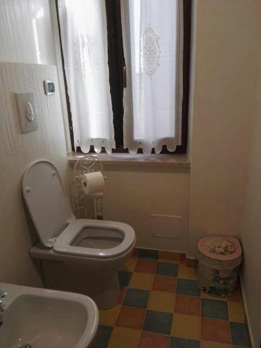 a bathroom with a toilet and a sink and a window at Il Giardino Dei Limoni in Montecassiano