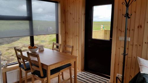 a dining room with a table and chairs and a window at Hekla Cabin 2 Volcano and Glacier View in Hella
