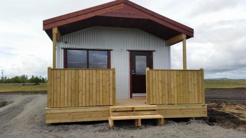a small building with a porch on a dirt road at Hekla Cabin 2 Volcano and Glacier View in Hella