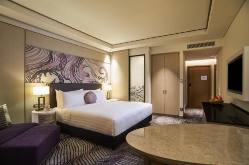 a hotel room with a bed and a couch at Amari Johor Bahru in Johor Bahru