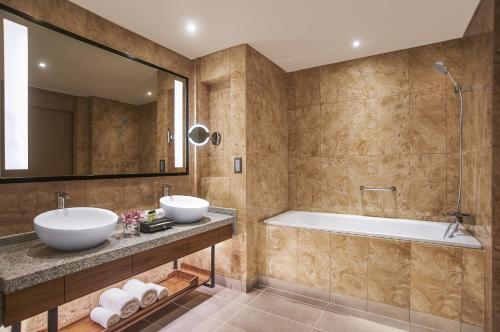 a bathroom with two sinks and a tub at Amari Johor Bahru in Johor Bahru