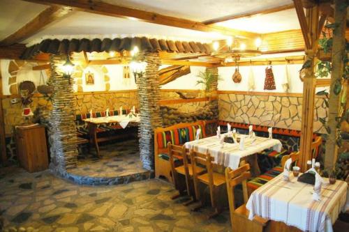 un restaurante con 2 mesas y una pared de piedra en Balkanski chanove, en Botevgrad