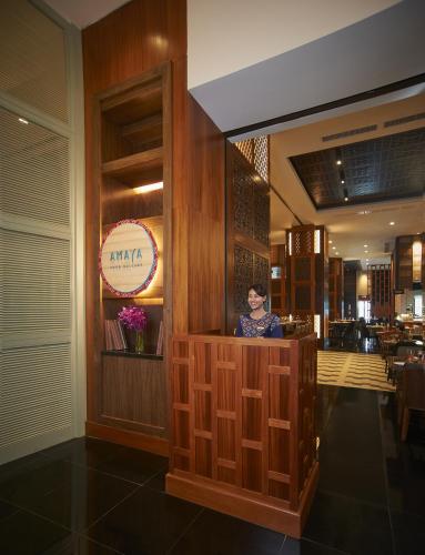 a woman sitting at a counter in a restaurant at Amari Johor Bahru in Johor Bahru