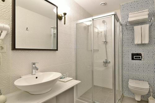 La salle de bains est pourvue d'un lavabo et d'une douche en verre. dans l'établissement Istanbul Life Hotel, à Istanbul