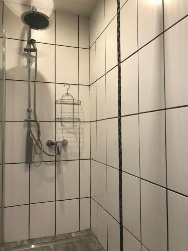 a shower in a white tiled bathroom at Ferienwohnung - Kurz in Sankt Wendel