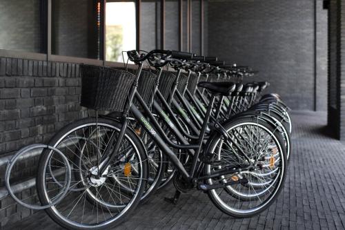 a row of bikes parked next to a brick wall at Wakeup Copenhagen - Borgergade in Copenhagen