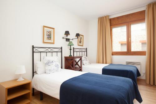 a bedroom with two beds and a window at Apartaments Les Terrasses del Tarter in El Tarter