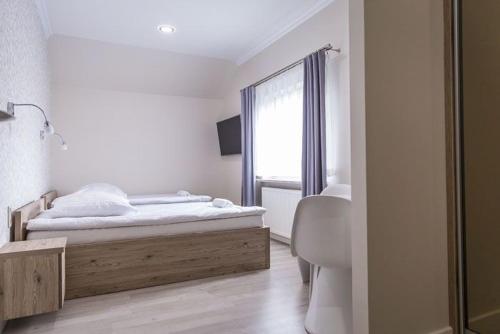 een witte kamer met een bed en een raam bij Oleńka in Kutno