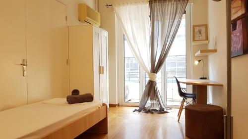 a bedroom with a bed and a window with a desk at Errathens Apartments - Athens Center in Athens