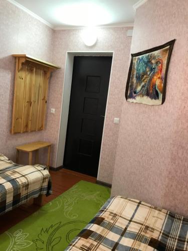 a room with two beds and a black door at Alakol-Jyrgalan Guest House in Dzhergalan