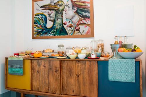 a buffet with fruit on it with a painting on the wall at Intervallo Boutique Hotel in Ragusa