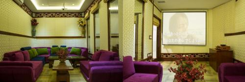 a waiting room with purple couches and a screen at SkyCity Hotel Gurgaon in Gurgaon