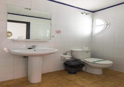 a bathroom with a sink and a toilet and a mirror at Albergue Inturjoven Córdoba in Córdoba