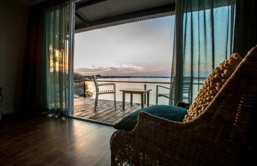 a living room with a view of the water at Zambezi Mubala Lodge in Katima Mulilo