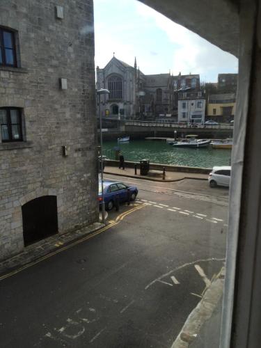 a view from a window of a street and water at Sailors Return Weymouth in Weymouth