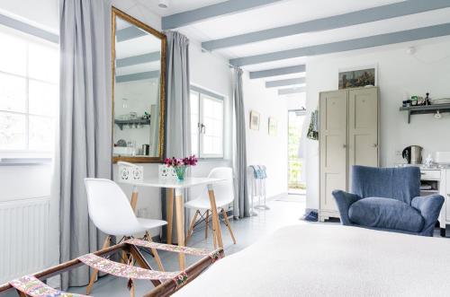 een kamer met een tafel en stoelen en een spiegel bij The Pool House in Den Dolder