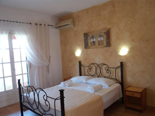 a bedroom with a bed and a window at Athineos Apartments in Kommeno