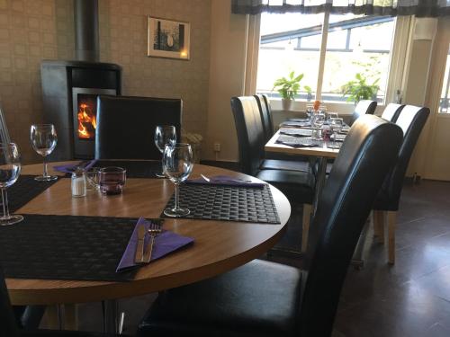 a dining room with two tables and a fireplace at Hotell Svanen in Kalmar