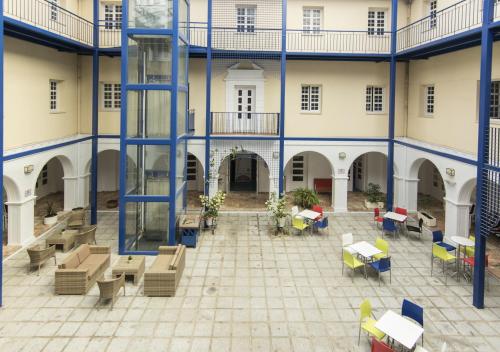 a courtyard with chairs and tables in a building at Albergue Inturjoven Huelva in Huelva