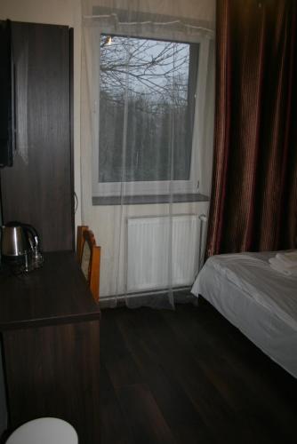 a small bedroom with a bed and a window at Pokoje Gościnne Tessa in Chełm
