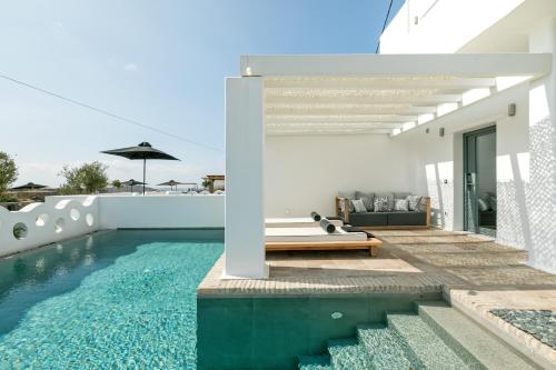 a villa with a swimming pool and a house at Portes Suites & Villas Mykonos in Mikonos