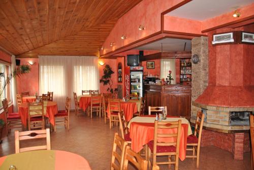 un ristorante con tavoli, sedie e un camino di Family Hotel Shoky a Chepelare