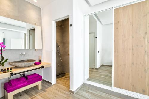 a bathroom with a sink and a mirror at Portes Suites & Villas Mykonos in Mýkonos City