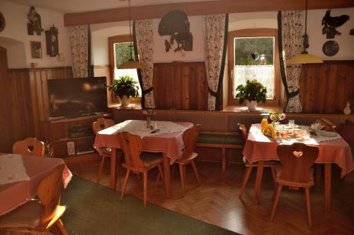 a dining room with two tables and a tv at Haus Jost Ingrid in Hermagor