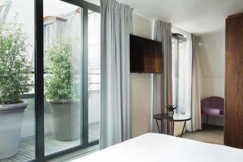 a bedroom with a bed and a large window at Maison Bréguet in Paris