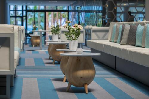 a room with couches and tables with flowers on them at Anastasia Waterpark Beach Resort in Protaras