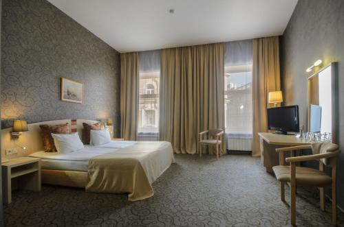 una camera d'albergo con letto e TV di 5th Corner Hotel a San Pietroburgo