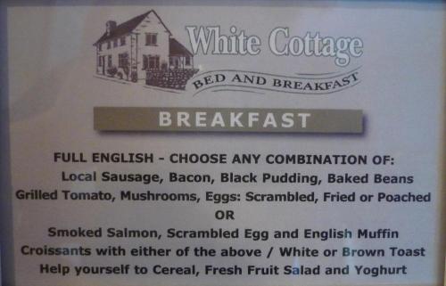 White Cottage Bed and Breakfast في Seisdon: لوحة لكوخ أبيض مع صورة منزل
