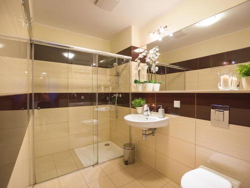 コウォブジェクにあるVacationClub - Olympic Park Apartment B307のバスルーム(シャワー、洗面台、トイレ付)