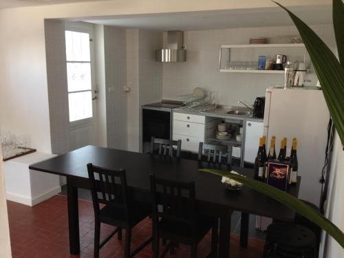 a kitchen with a table with chairs and a refrigerator at AirPorto Hostel in Maia