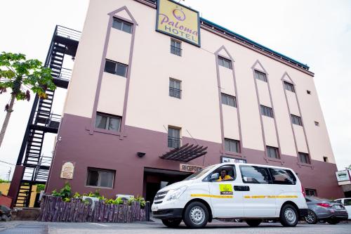 a white van parked in front of a building at Paloma Hotel Ring Road in Accra